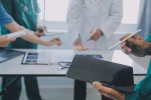A group of doctors discuss a missed diagnosis around a table.