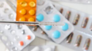 Pills and a thermometer to represent a medication error claim.
