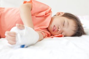 A child is sleeping wearing an arm cast 