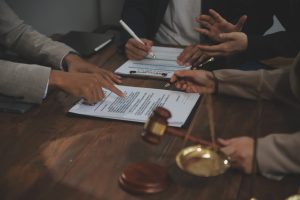 A group of medical negligence solicitors sat at a table with legal contracts and a gavel