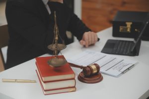A solicitor surrounded by books, papers and a gavel working on lung cancer misdiagnosis claims.
