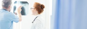 Two doctors examining a lung scan carefully to avoid lung cancer misdiagnosis claims